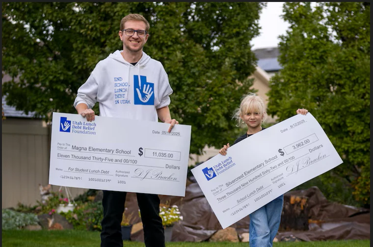 Founder DJ Bracken and his daughter Liara holding school lunch debt relief checks
